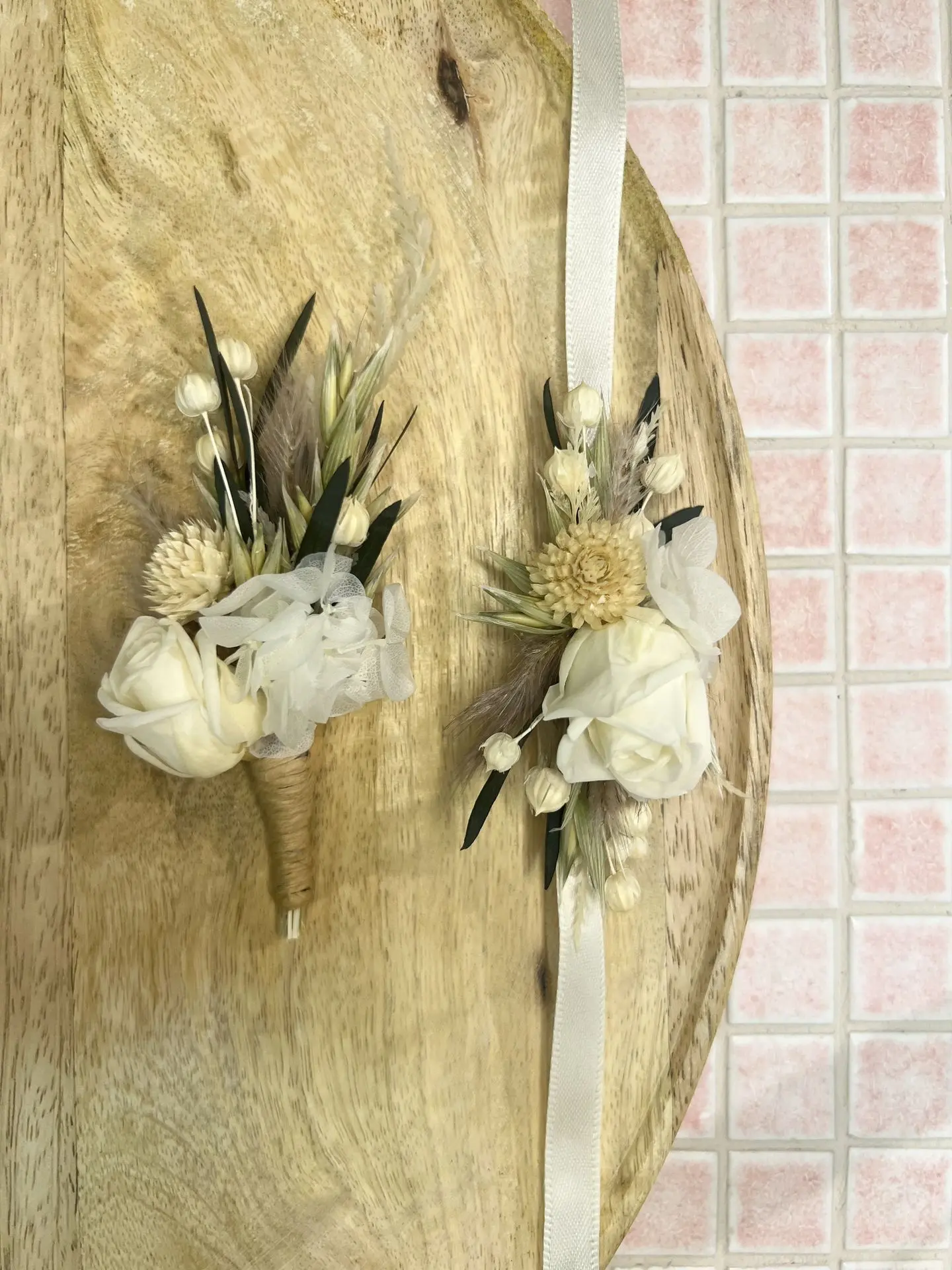 Photo d'une boutonnière et d'un bracelet en fleurs séchées et stabilisées (rose et hortensia), les fleurs sont blanche et verte